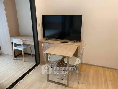 Modern compact living room with sleek TV setup and stylish dining area.