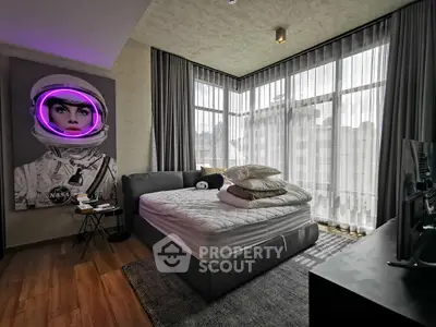 Modern bedroom with large windows and unique astronaut artwork, featuring a cozy bed and stylish decor.