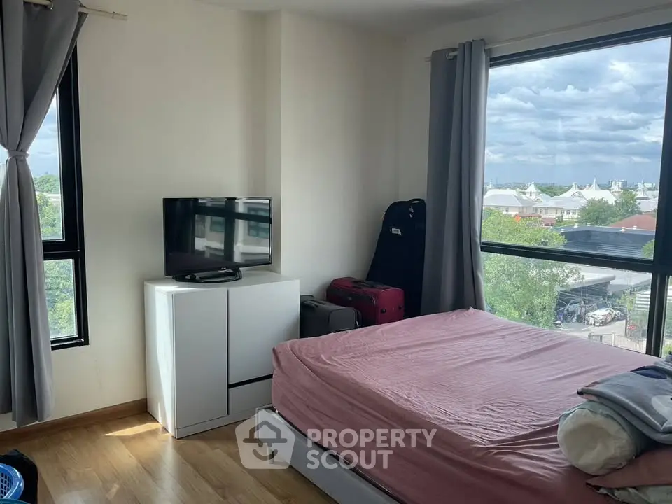 Cozy bedroom with large windows offering a scenic view, featuring a comfortable bed and modern decor.