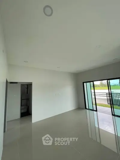 Spacious modern living room with large sliding glass doors and balcony access.