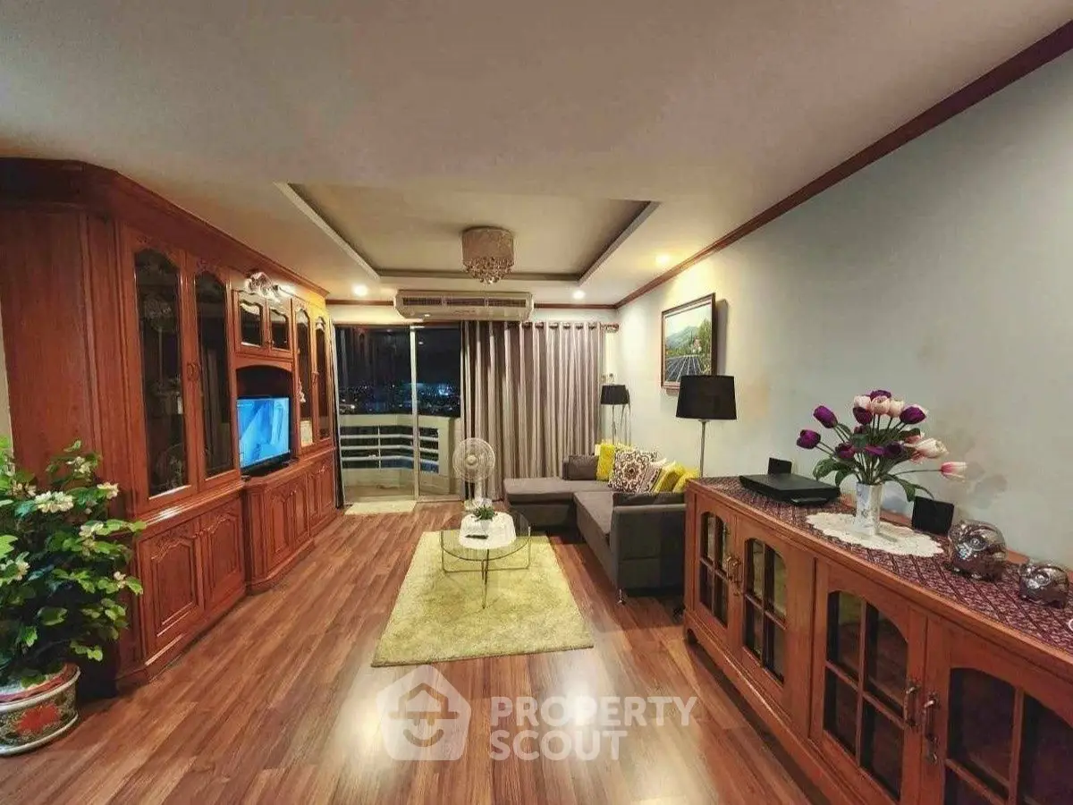 Spacious living room with elegant wooden furniture and balcony view