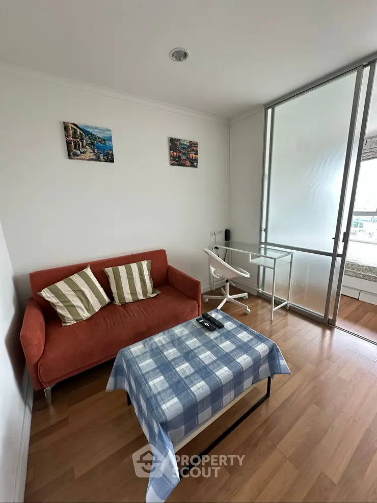Cozy living room with modern decor and natural light, featuring a compact sofa and stylish table.