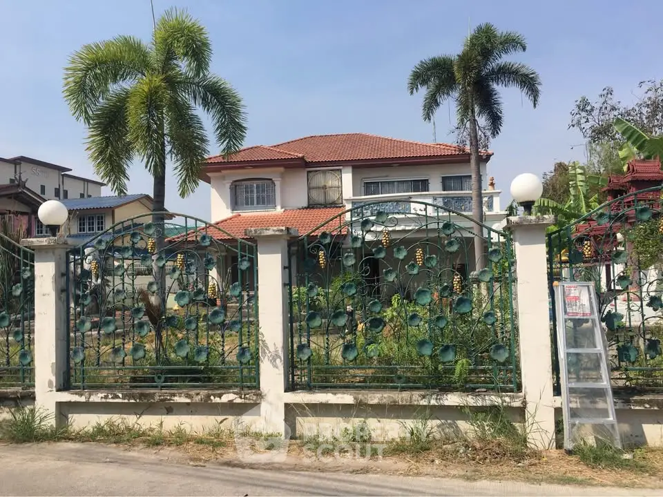 Charming two-story house with lush garden and decorative fence in a serene neighborhood.