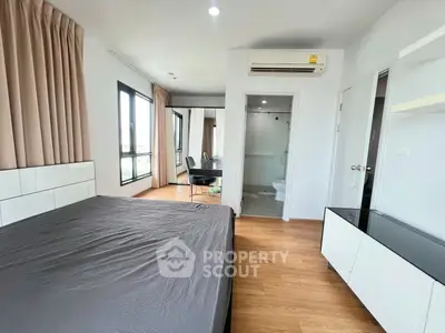 Modern bedroom with ensuite bathroom and large windows in a stylish apartment.