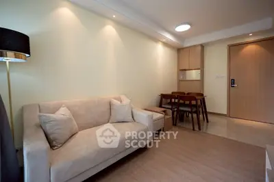 Modern living room with beige sofa and dining area in cozy apartment