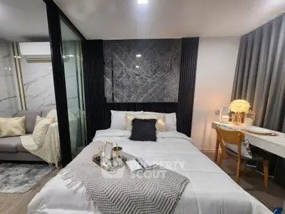 Modern bedroom with elegant decor, cozy bed, and stylish workspace in a chic apartment.