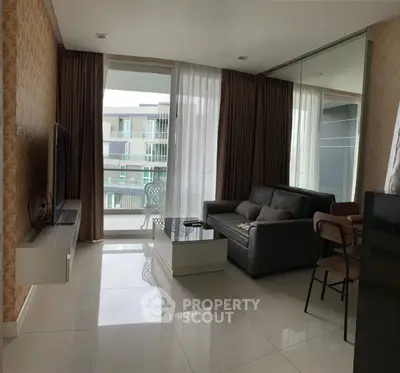 Modern living room with balcony view, sleek furniture, and elegant decor in a contemporary apartment.
