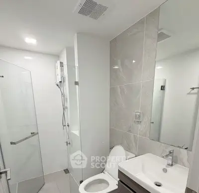 Modern bathroom with glass shower and sleek fixtures in a contemporary apartment.