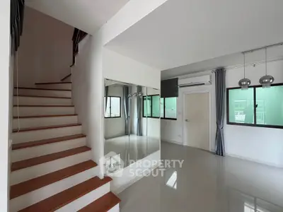 Modern interior with staircase and large windows in a bright living space