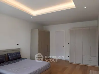 Spacious modern bedroom with sleek wardrobes and cozy lighting
