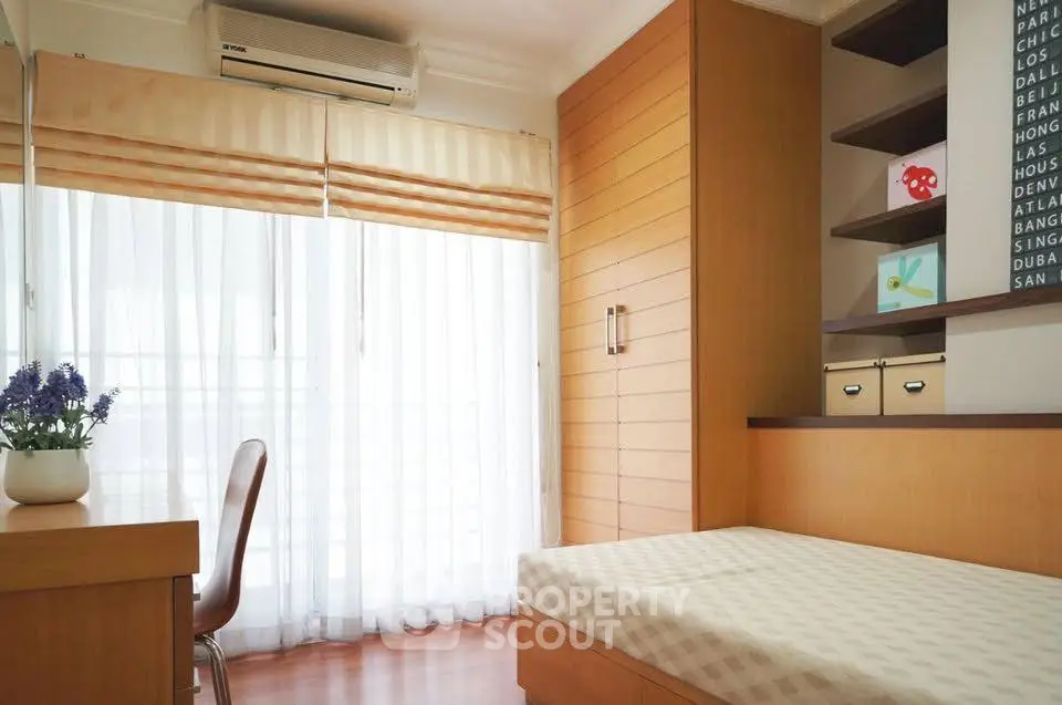 Bright and cozy bedroom with modern furnishings and large window.
