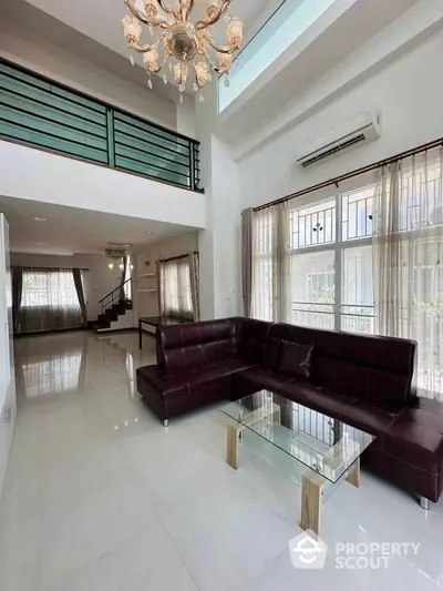 Spacious modern living room with high ceiling and elegant chandelier