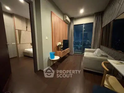 Modern apartment living room with city view, featuring stylish furniture and wooden flooring.