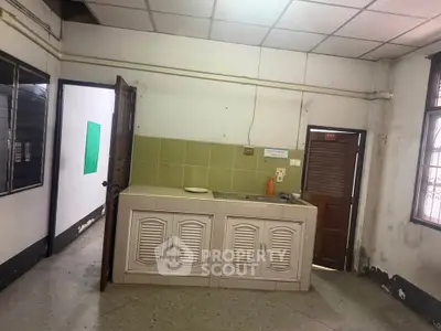 Spacious kitchen area with closed layout and vintage cabinetry, ideal for renovation.