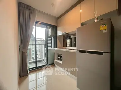 Modern kitchen with sleek appliances and balcony view in urban apartment