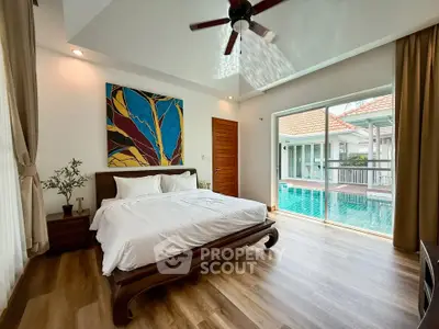 Luxurious bedroom with pool view and modern decor in a stunning real estate property.