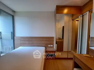Modern bedroom with wooden accents and mirrored wardrobe in a stylish apartment.