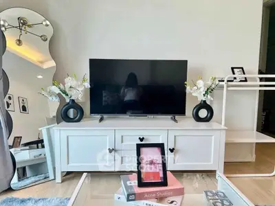 Stylish living room with modern decor, featuring a sleek TV stand and elegant floral arrangements.