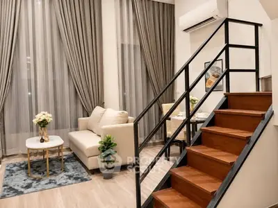 Modern living room with elegant staircase and cozy seating area