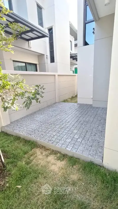 Modern exterior patio with sleek paving and lush greenery