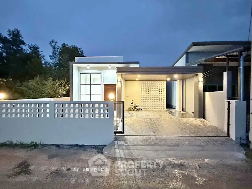 Modern single-story home with sleek design and spacious driveway at dusk.