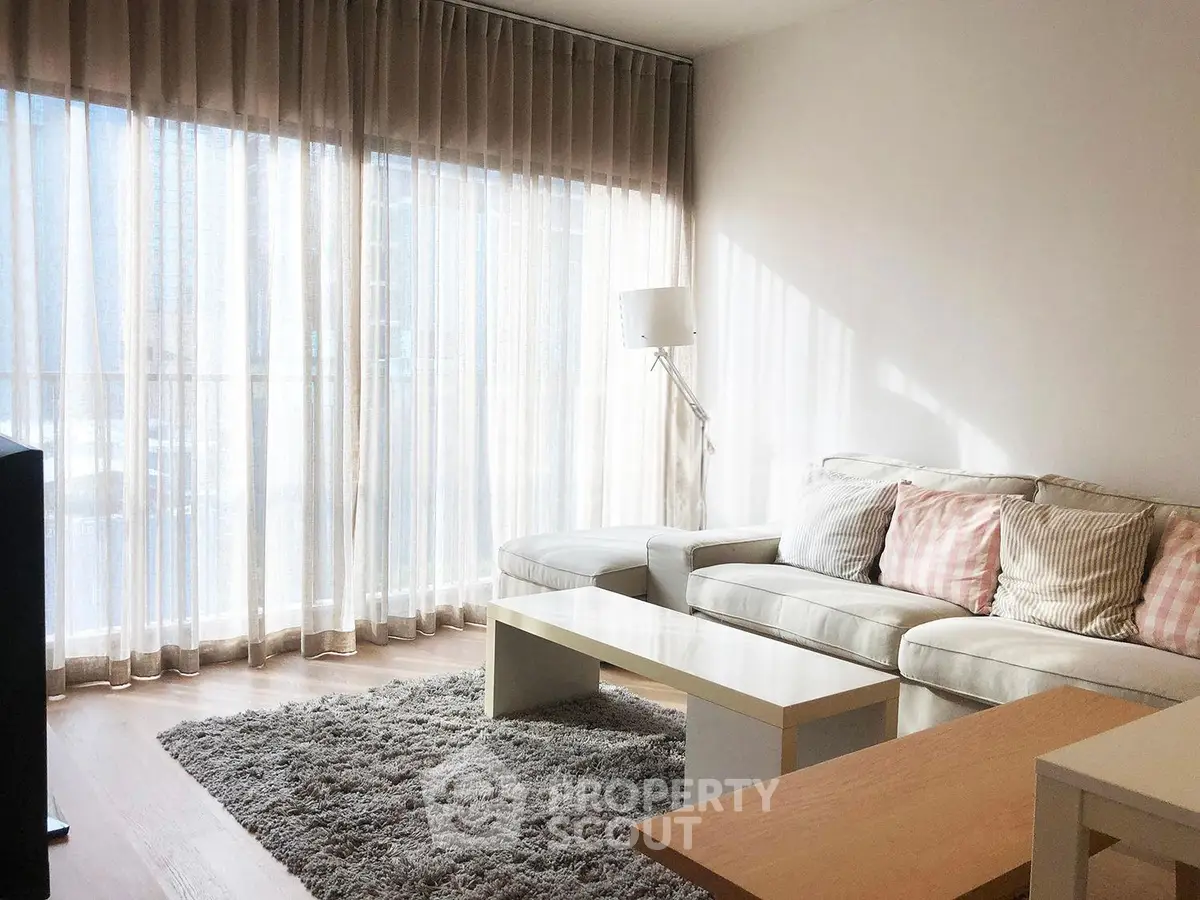 Bright and cozy living room with modern furniture and large windows.