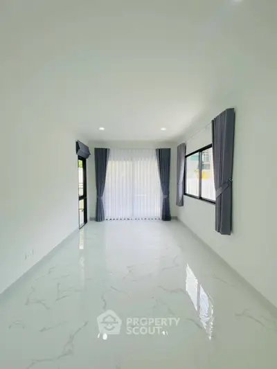 Spacious and bright living room with elegant marble flooring and large windows for natural light.