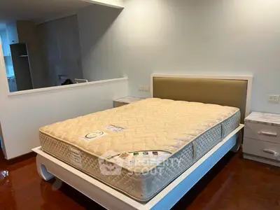 Spacious bedroom with modern bed and stylish decor in a well-lit apartment.