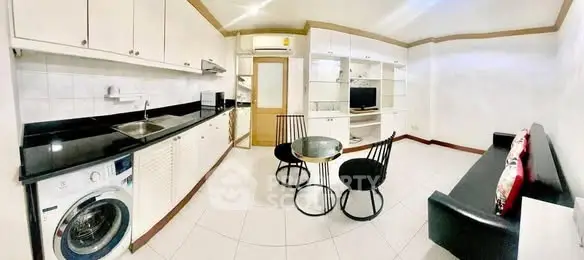 Modern open-layout kitchen and living area with sleek furniture and built-in appliances.