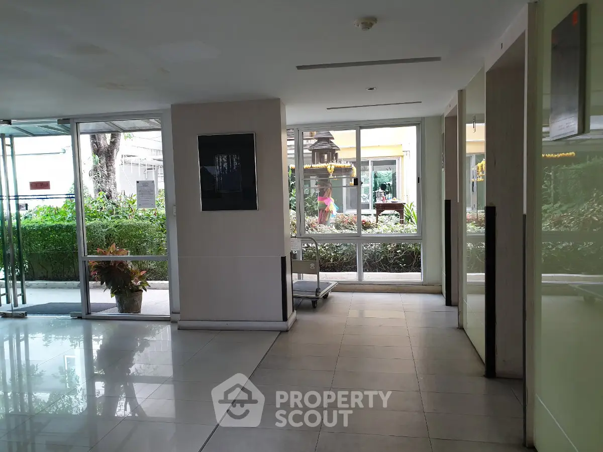 Spacious building entrance with large windows and garden view, ideal for welcoming guests.