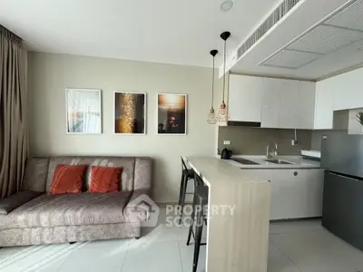 Modern open-layout kitchen and living room with stylish decor and natural light.