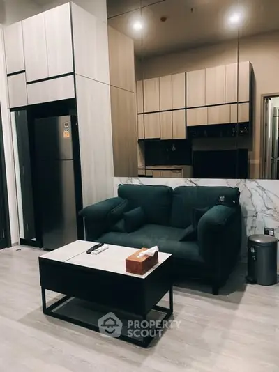 Modern living room with sleek kitchen, featuring stylish cabinetry and cozy seating area.