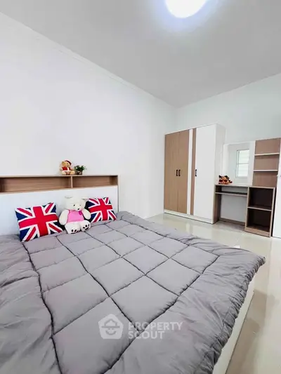 Modern bedroom with stylish decor and ample storage space, featuring a cozy bed and sleek wardrobe.
