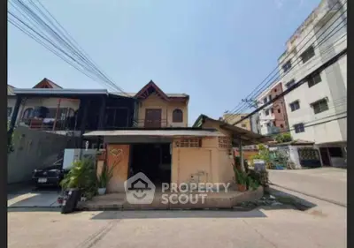 Charming residential house with unique architectural design and lush greenery in urban neighborhood.