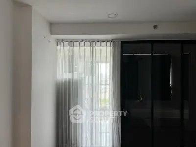 Modern bedroom with sheer curtains and glass partition