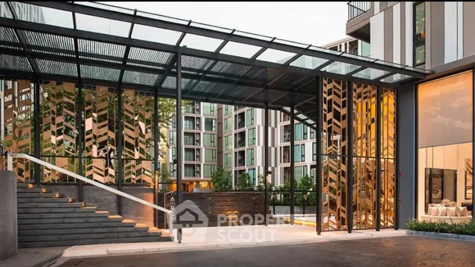 Modern apartment building entrance with stylish design and glass canopy