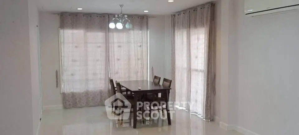 Spacious dining area with elegant curtains and modern lighting