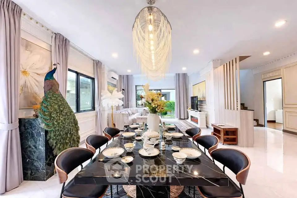 Luxurious dining room with elegant decor and modern chandelier in a spacious open-plan living area.
