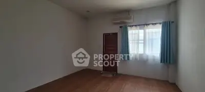 Spacious empty room with wooden door and window, ideal for customization.