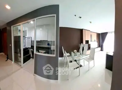 Modern open-plan living and dining area with sleek kitchen design.