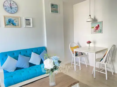 Charming living room with vibrant blue sofa and cozy dining area, perfect for modern living.