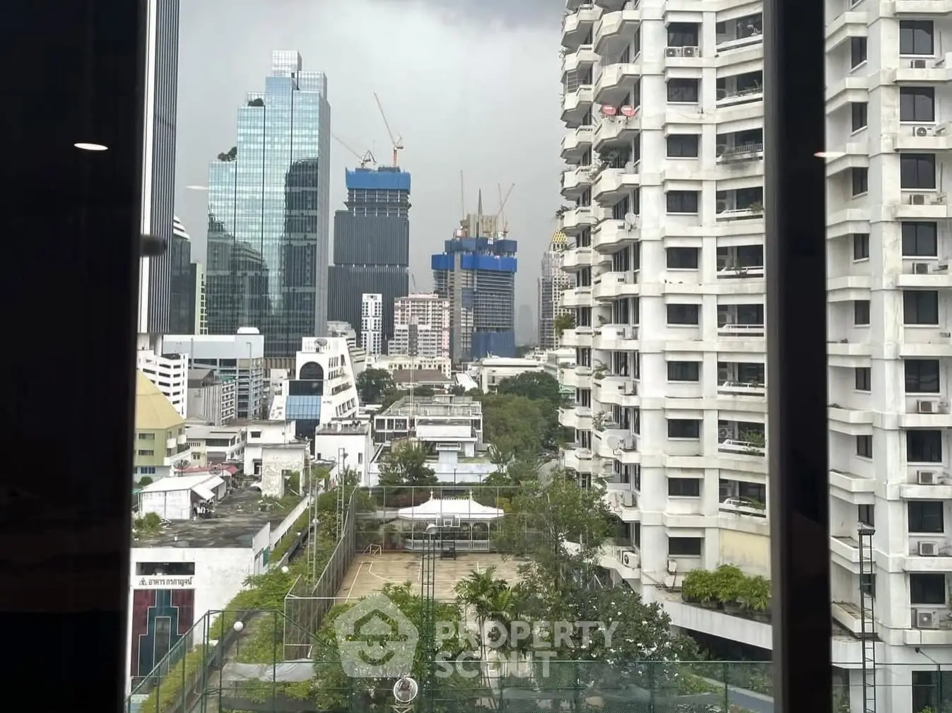 Stunning urban view from high-rise window showcasing city skyline and modern architecture.