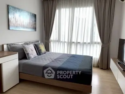 Modern bedroom with large window and stylish decor in a contemporary apartment.