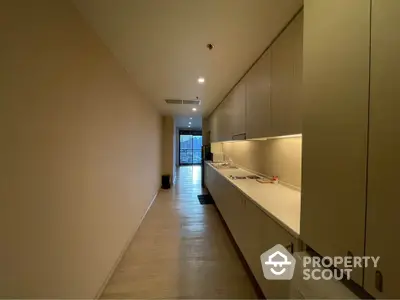 Modern kitchen with sleek cabinetry and long countertop in a contemporary apartment.