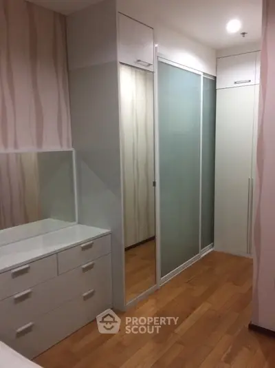 Spacious modern storage area with sleek sliding doors and elegant wood flooring.