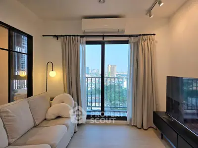 Modern living room with city view, cozy sofa, and large TV, perfect for relaxation and entertainment.