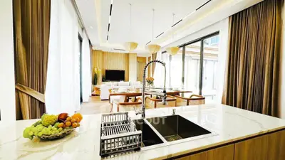 Luxurious open-plan kitchen and living room with elegant decor and ample natural light.