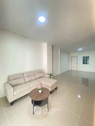 Spacious living room with modern beige sofa and sleek tiled flooring