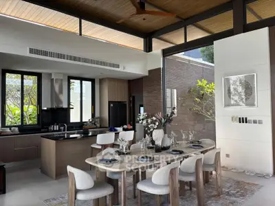 Luxurious open-plan kitchen and dining area with modern decor and large windows.
