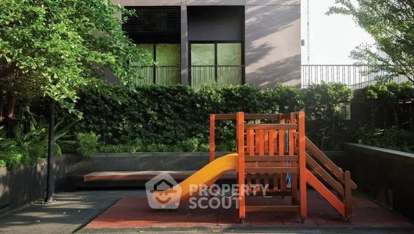 Charming residential playground with slide surrounded by lush greenery, perfect for family-friendly living.